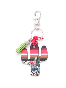 Detail of wooden cactus keychain with leopard print, flower patterns and green tassel