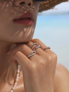 Dettaglio di quattro anelli in argento con perle e diamanti per uno stile estivo