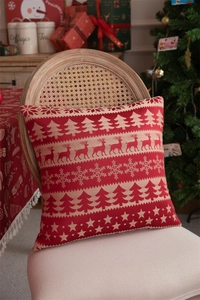 Detail of Christmas throw pillow with reindeer and snowflake pattern on wooden chair