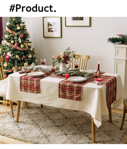 Close-up of red plaid Christmas table runner with snowflake pattern on white tablecloth