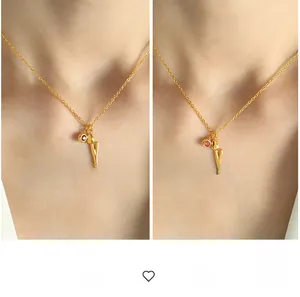 Detail of 18k gold plated necklace featuring tulip pendant and red crystal charm