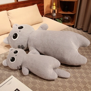 Detail of plush grey cat long pillows in two sizes on a cozy wooden bed setting