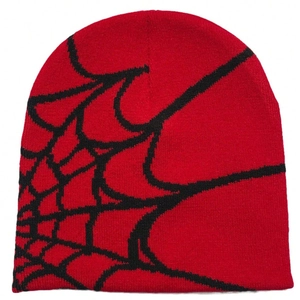 Detail of red jacquard knit beanie featuring black spider web pattern and texture