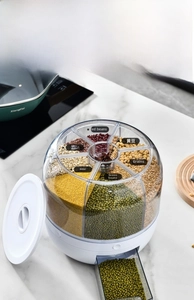 Rotating grain dispenser with six transparent compartments for cereal storage on kitchen counter