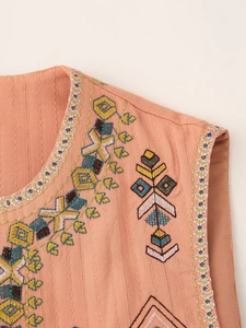 Close-up of geometric floral embroidery details on pink ethnic vest for women