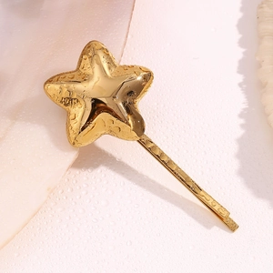 Macro view of 18K gold plated star hair clip with realistic water droplets on surface