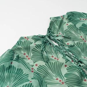 Detail of green floral chiffon maxi dress featuring back neck-tie and scallop print texture