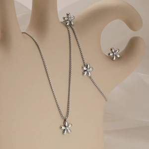 Elegant stainless steel flower jewelry set with sparkling crystals on a beige display