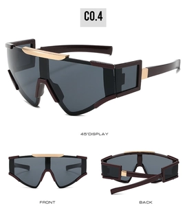 Macro detail of oversized cycling sunglasses with gold metal accents and dark grey lenses
