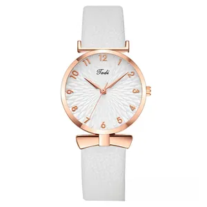 Detail of rose gold watch case with bow decoration and white embossed texture dial