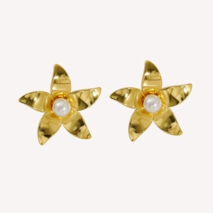 Detailed view of polished gold flower earrings with elegant white pearl center