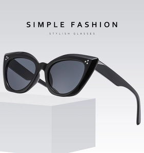 Close-up of black cat-eye sunglasses featuring three silver rivet studs on a sleek frame