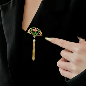 Detail of 18K gold fan brooch with pink enamel flowers and pearl tassel on a black blazer