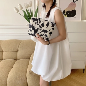 Close-up of cow pattern floral fabric cosmetic bag with durable zipper and brand label