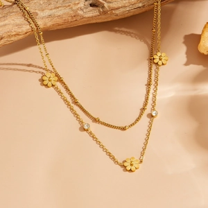 Collier marguerite double couche plaqué or 18k avec zircons sur une branche en bois rustique