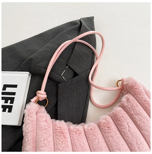 Borsa a mano in peluche rosa con sottile tracolla in pelle e dettagli in metallo dorato