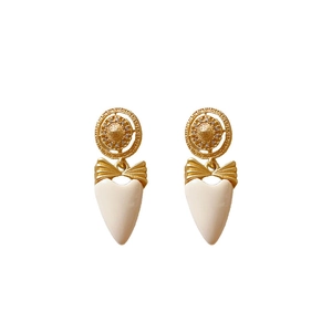 Vintage palace style earrings with golden bow and white heart drop on white background