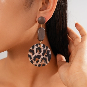 Close-up of leopard print acrylic geometric earrings worn by model for retro autumn style