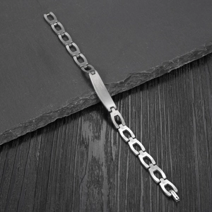 Sleek silver stainless steel punk bracelet with rectangular plate on dark rock base