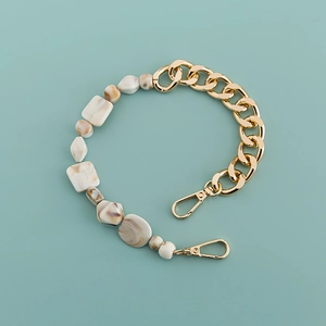 Detailed view of colorful acrylic resin beads and gold metal chain with lobster clasps