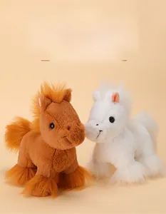 Close-up of soft brown and white plush pony toys with fluffy mane on warm background