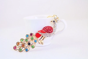 Detail shot of golden peacock keychain with vibrant colorful rhinestone embellishments