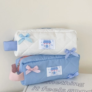Detailansicht gesteppter Kosmetiktaschen mit Schleifen in Beige und hellem Blau