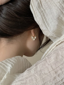 Close-up of gold plated pearl earrings with zircon heart detail on female model