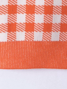 Detail of orange and white checkered knit top showing the ribbed hem and soft fabric texture