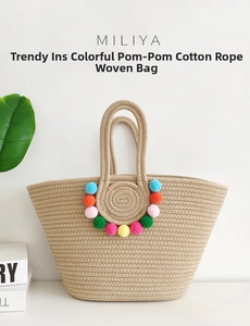 Detail of handmade cotton woven tote bag featuring vibrant colorful decorative pom poms