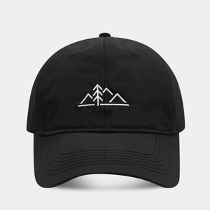 Détail d'une casquette de baseball noire avec broderie de montagne et de forêt à l'avant