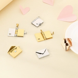 Detailed macro view of heart-cutout envelope and book lockets in gold and silver