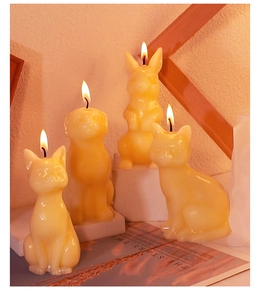 Lit animal-shaped candles featuring cat, dog, and rabbit designs on a display stand