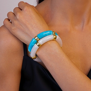 Détail de bracelets en acrylique bleu ciel marbré et blanc perle avec anneaux dorés