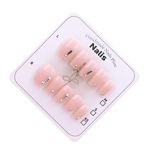 Faux ongles faits main rose poudré avec paillettes argentées sur carte de présentation