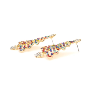 Macro detail of Christmas tree earrings with colorful rhinestones on gold metal
