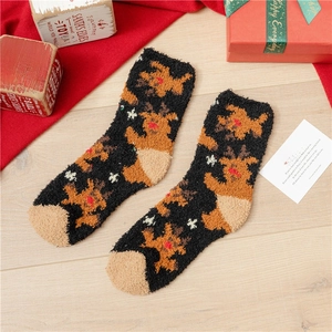 Detail of soft coral fleece Christmas socks featuring brown reindeer and snowflakes