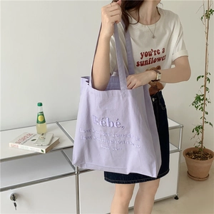 Detail der lila Canvas-Tasche mit lila Bébé-Stickerei und Motivationsspruch