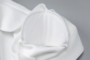 Detail of white knitted semi-circle shoulder pads with fine overlock stitched edges