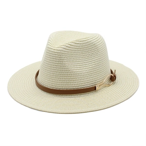 Detailed texture of cream straw fedora hat featuring a brown leather band and gold metal buckle