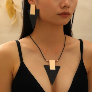 Parure de bijoux géométriques avec pendentifs triangulaires et boucles sur un mannequin