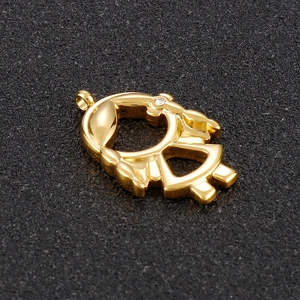 Golden girl silhouette pendant with small clear rhinestone inlay on black background