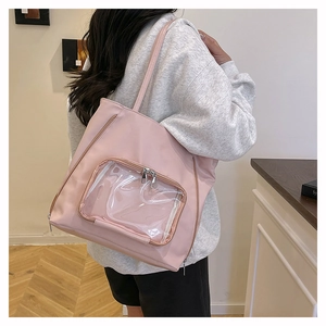 Borsa tote in nylon rosa con finestra in PVC trasparente indossata a spalla dal modello