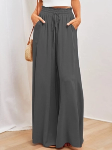 Detail of high-waist dark grey wide-leg trousers with elastic drawstring waist and side pockets