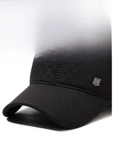 Gros plan d'une casquette de baseball noire matelassée avec écusson métallique latéral