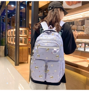 Close-up of a purple bear backpack with multiple pockets worn in a stylish lifestyle setting
