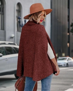 Dettaglio della spessa maglia bordeaux e dell'alto collo a lupetto del poncho morbido