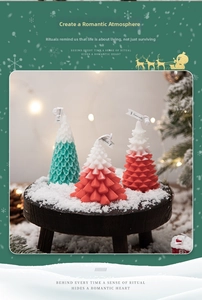 Close-up of tree-shaped scented candles on a snowy wooden base with festive decor