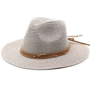 Close-up of light gray fedora straw hat with brown suede strap and gold bead detail