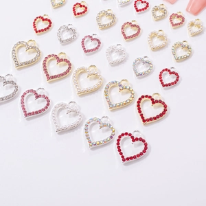 Macro detail of alloy hollow heart nail charms with rhinestones and pearls for DIY jewelry